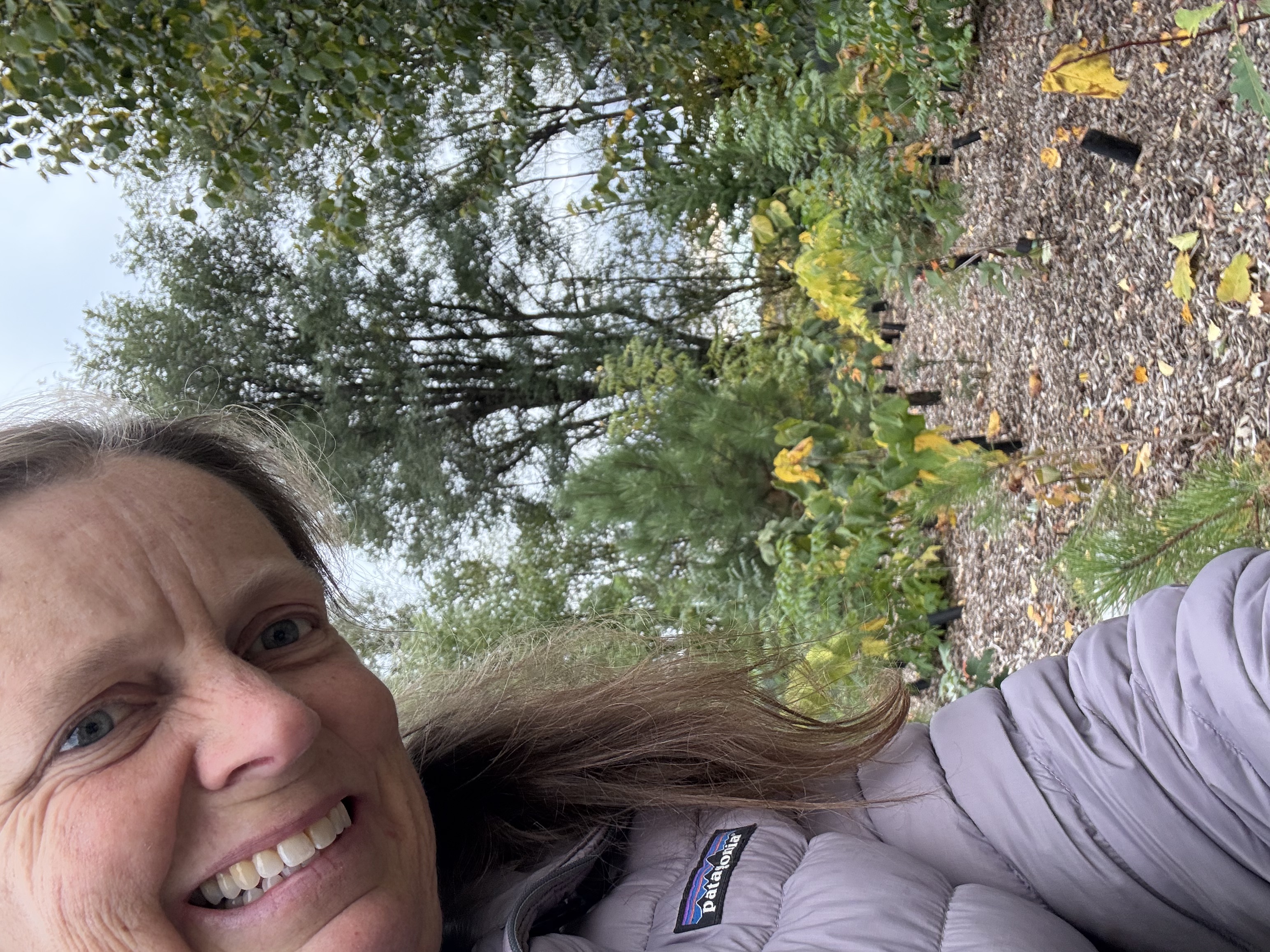 Karen at the Terry Fox tiny forest, the dense planting visible behind her